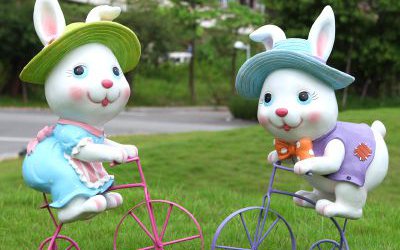 公園玻璃鋼騎自行車的卡通兔子雕塑