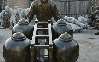 景區(qū)創(chuàng)意玻璃鋼仿銅民俗推車(chē)送酒的人物雕塑