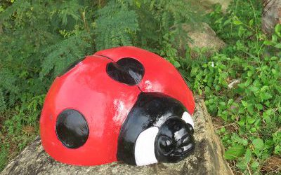 在石頭上趴著的玻璃鋼彩繪七星瓢蟲雕塑